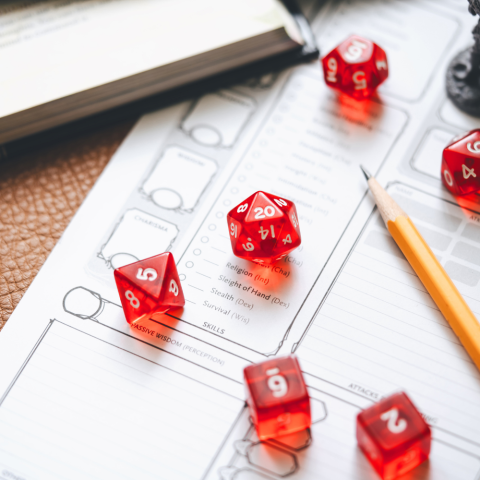 Dungeons and dragons dice on top of a blank character sheet