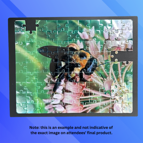 Photo of a sublimination puzzle on a blue background. The puzzle is mostly completed and showcases a photograph of a bee on a flower.