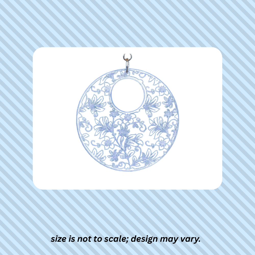 photo of acrylic pendant over white rectangle over a blue striped background