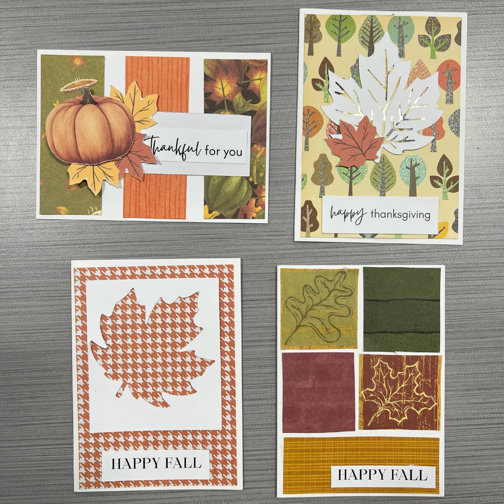 Four thanksgiving and autumn-themed handmade cards on top of a gray counter